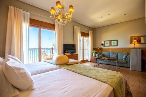a bedroom with a large bed with a chandelier at Hotel Los Ángeles Denia in Denia