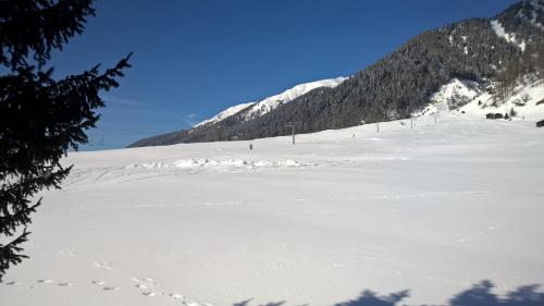 a snow covered ski slope with mountains in the background at Chalet Daheim in Reckingen - Gluringen