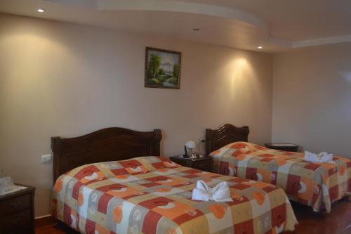 a hotel room with two beds in a room at Hotel Las Brumas in Cartago
