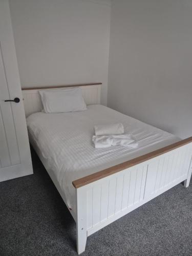 a white bed with two towels on top of it at James' Place @1 Gwynnes in Merthyr Tydfil