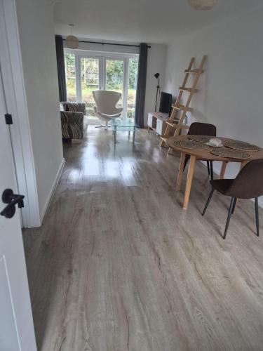 a living room with wooden floors and a table and chairs at James' Place @1 Gwynnes in Merthyr Tydfil