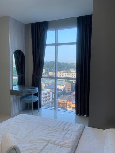 a bedroom with a bed and a large window at Skyline Z in Mantaak