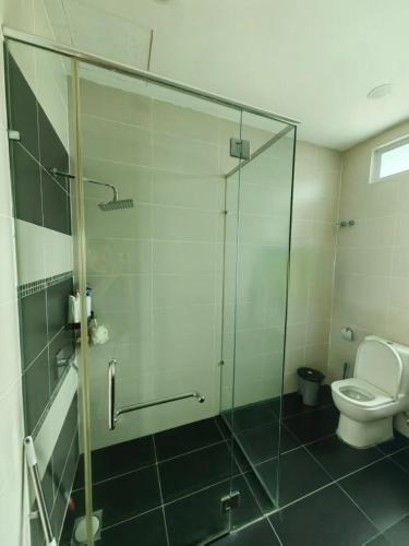 a bathroom with a glass shower and a toilet at Lakeside house in Gua Sai