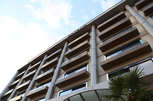 a facade of a building with a palm tree at Athens Zafolia Hotel in Athens