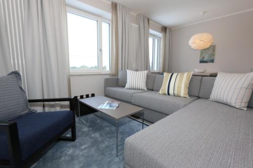a living room with a couch and a table at Prora Block 1 - Sauna, Pool und Fitness - Meerzeit in Binz