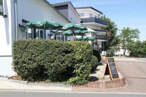 a sign in front of a restaurant with umbrellas at Gästehaus Wilhelmshöhe in Butzbach