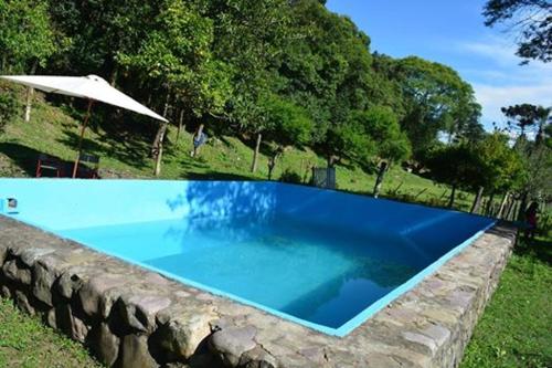 a large blue swimming pool in a stone wall at Finca La Colorada in San Salvador de Jujuy