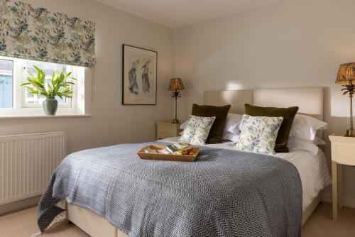 a bedroom with a bed with a tray of food on it at Easy Oars - Flushing, Falmouth in Flushing