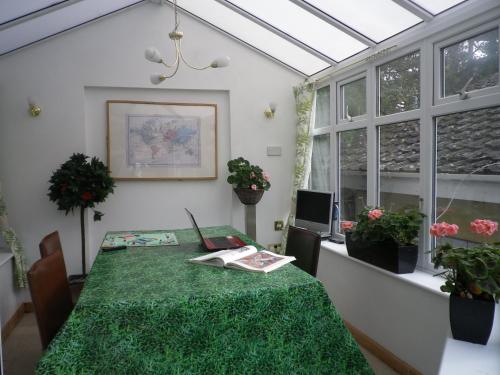 een kamer met een tafel met een groene tafelkleed bij Bridge Hall Apartments in Weston-super-Mare