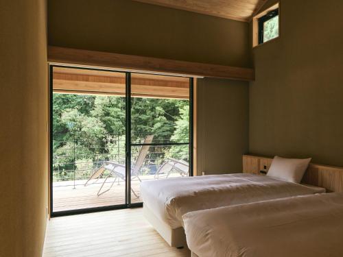 a bedroom with a bed and a large window at GEOSPOT Motohakone C 2026年1月 New Open in Hakone