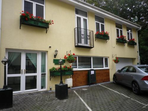 a yellow building with flower boxes on the windows at Bridge Hall Apartments in Weston-super-Mare