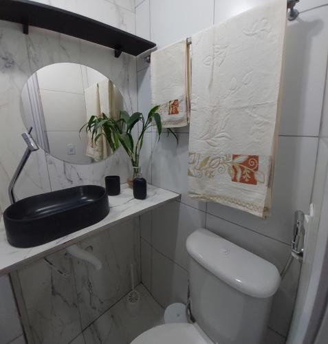 a bathroom with a toilet and a sink and a mirror at Casa da Angela Quarto Triplo in Rio de Janeiro