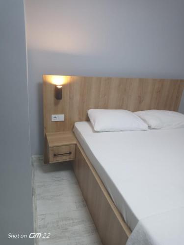 a bedroom with a white bed and a night stand at Tekirdağ Begonya Hotel in Kapaklı