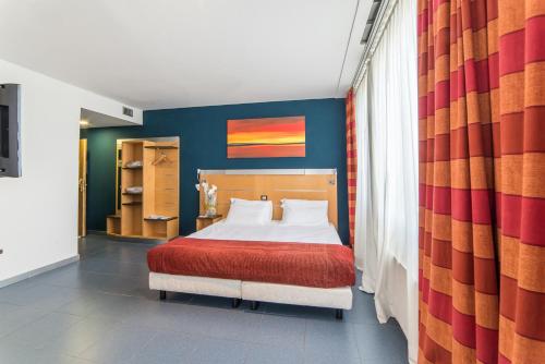 een slaapkamer met een bed met een rode deken bij Sotel Nomentana Roma in Rome