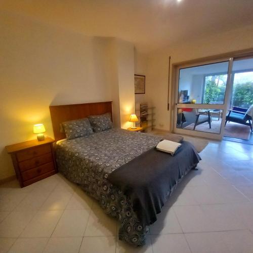 a bedroom with a large bed and a large window at Apartment with Private Garden in Porto