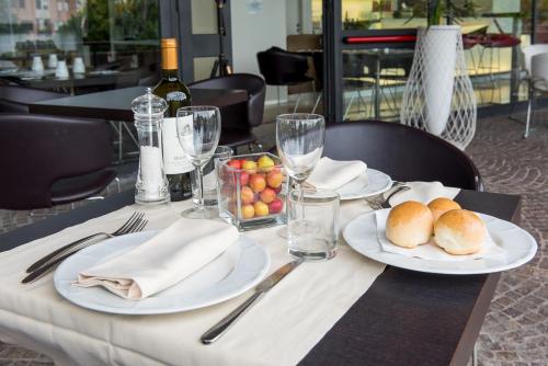 a table with plates of food and wine glasses at Sotel Nomentana Roma in Rome
