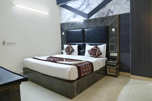 a bedroom with a large bed with a black headboard at Hotel HSP Suites - Near IGI Airport, New Delhi in New Delhi