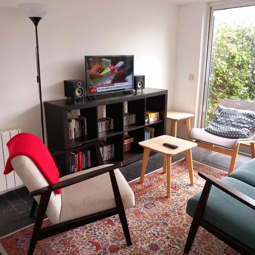 a living room with a television on a book shelf at Apartment with Private Garden in Porto