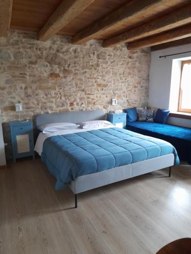 a bedroom with a large blue bed and a couch at Casa 1885 in Belluno