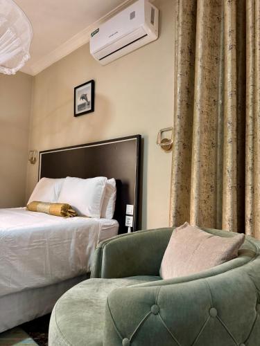 a bedroom with a bed and a chair and a couch at Annavilla7 Lilongwe hotel in Lilongwe