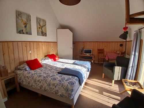a bedroom with a bed and a chair at Hoeve Op Vollenhof in Wezep