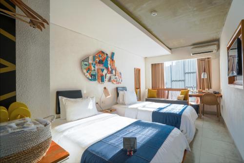 a hotel room with two beds and a table at YATS Colony in Yogyakarta
