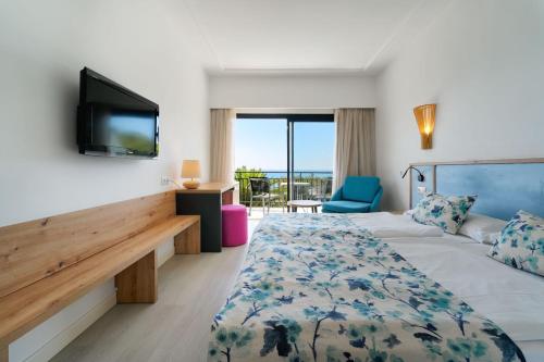 a hotel room with a bed and a tv at R2 Lago Playa Park in Cala Ratjada