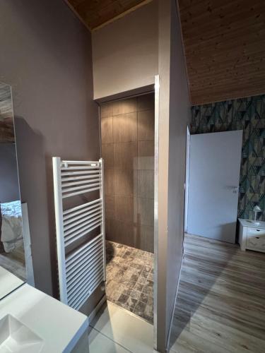 a bathroom with a walk in shower next to a door at Le Montagnon in Lupé