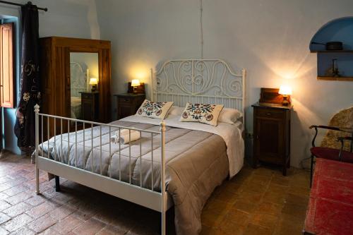 a bedroom with a bed with a metal frame and pillows at Al Casolare in Ofena
