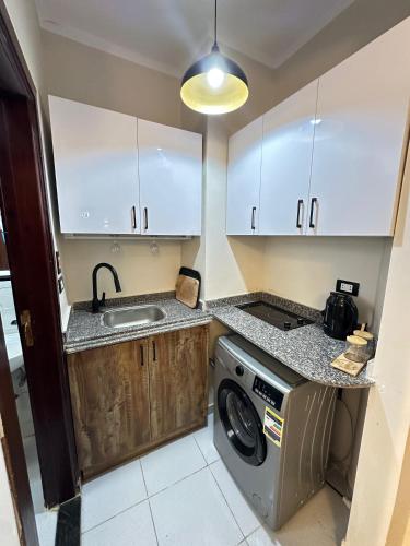 a kitchen with a washing machine and a sink at Downtown Keys in Hurghada