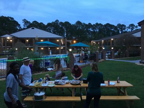 a group of people standing around a picnic table at At Home Inn - Pensacola in Pensacola