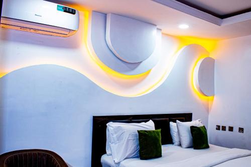 a bedroom with a bed with a tv on the wall at Fobbs Apartment and Suites in Asaba