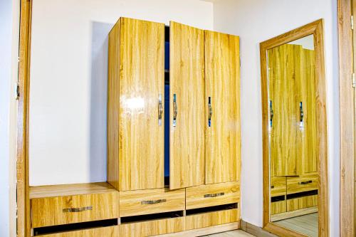 a room with wooden cabinets and a mirror at Fobbs Apartment and Suites in Asaba