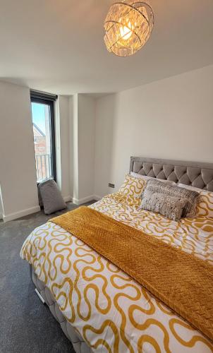 a bedroom with a large bed and a chandelier at Grace House in St. Albans