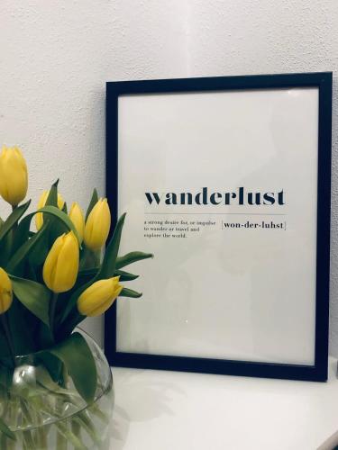 a picture frame with a vase of yellow flowers at Wanderlust Chiemgau in Bad Endorf