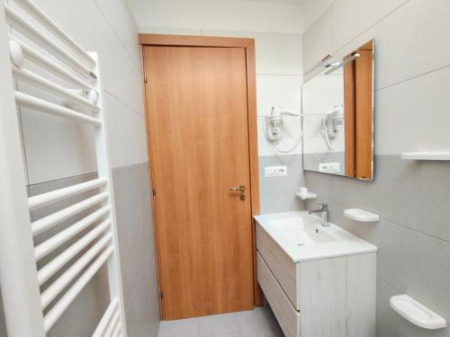 a bathroom with a wooden door and a sink at Le Zagare Case Vacanza in Cropani
