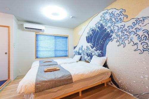 a bedroom with a large wave mural on the wall at Seed INN Haneda Terrace 201 in Tokyo
