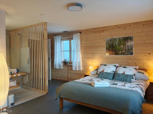 a bedroom with a large bed and a window at B&B Le Chalet in Les Sciernes d'Albeuve