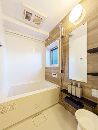 a bathroom with a tub and a toilet and a sink at Seed INN Haneda Terrace 201 in Tokyo