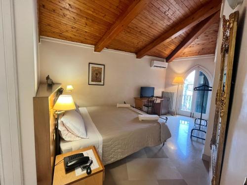 a bedroom with a bed and a desk with a lamp at Palazzo Sottile Meninni - CLASSIC ROOMS EXPERIENCE in Gravina in Puglia
