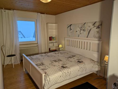 a bedroom with a white bed and a window at Kaisers Ferienhof in Hallenberg