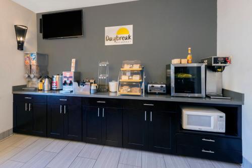 a counter in a room with a microwave and appliances at Hotel 1550 - SFO Airport West in San Bruno