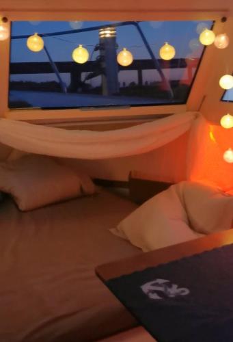 a bedroom with a bed with a view of a lighthouse at Sleeping on the GilgaBoat! in Nakskov