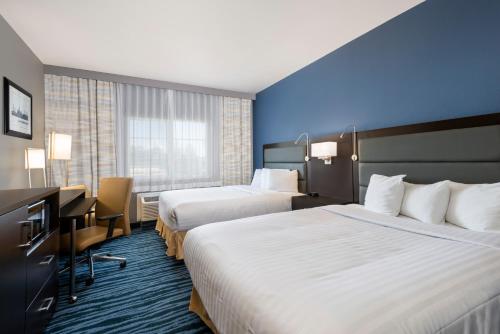 a hotel room with two beds and a desk at Hotel 1550 - SFO Airport West in San Bruno