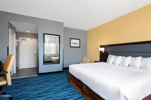 a hotel room with a large bed and a mirror at Hotel 1550 - SFO Airport West in San Bruno