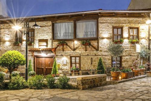 a stone house with a courtyard in front of it at Hagiati Guesthouse - Edessa Cozy Mountain Retreat in Edessa