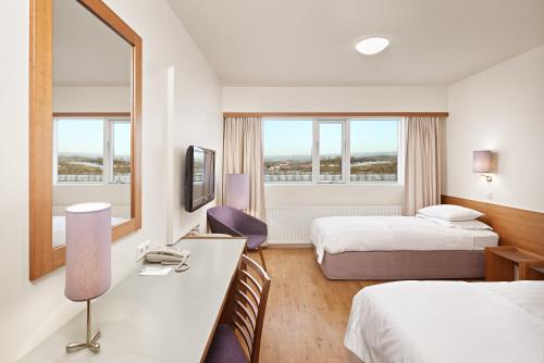 a hotel room with two beds and a desk at Hérað - Berjaya Iceland Hotels in Egilsstaðir