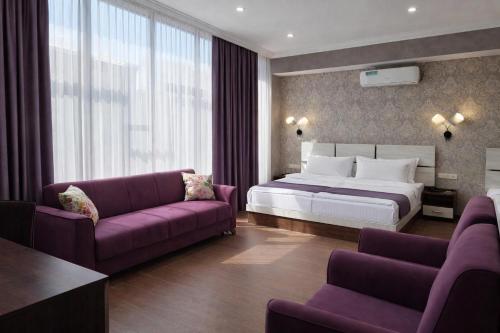 a bedroom with a large bed and purple furniture at Cherry Garden Boutique Hotel in Yeghegnadzor