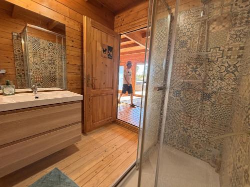 a bathroom with a shower and a person walking in the doorway at Casa na Colina in Almancil