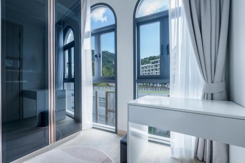 a bathroom with large windows and a white tub at Palmetto Park Residence in Karon Beach